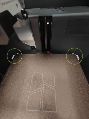 Ensure the back of the build plate is between these plastic tabs